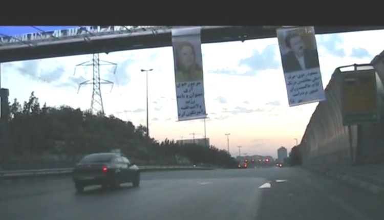 تعليق لافتات لصور مسعود و مریم رجوي في طريق حکیم السريع 