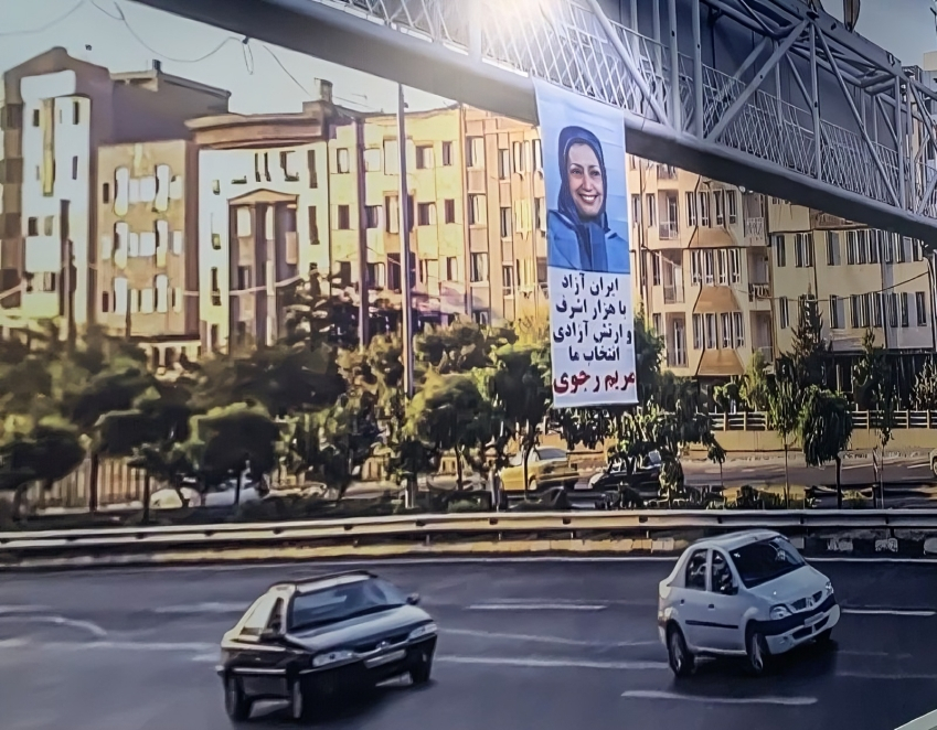 شباب إيرانيون يعلّقون لافتة ضخمة لمريم رجوي في قلب طهران… رسالة تحدٍّ للنظام في خطوة جريئة تعكس تصاعد الغضب الشعبي داخل إيران، أقدم شباب من أنصار الحرية على تعليق لافتة ضخمة تحمل صورة السيدة مريم رجوي، رئيسة الجمهورية المنتخبة من قبل المجلس الوطني للمقاومة الإيرانية، على جسر للمشاة في العاصمة طهران.