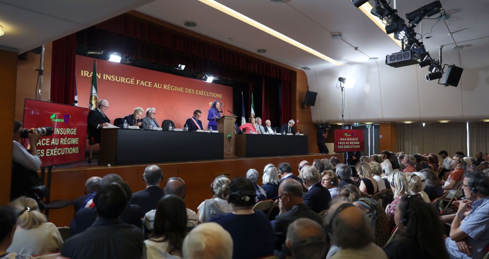 Panel of speakers and attendees at the Paris District 17 Conference, standing united in support of a free and democratic Iran.