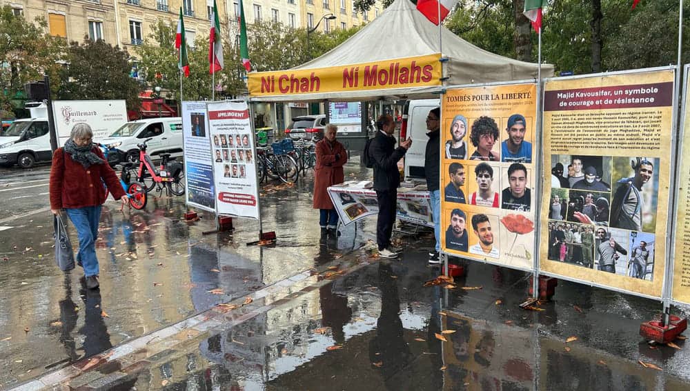 PMOI supporters in Paris display books and photos exposing the Iranian regime’s executions of political prisoners and uprising protesters.